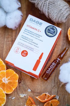 Close-up of Vitamin C skincare product with orange slices and cotton for freshness.