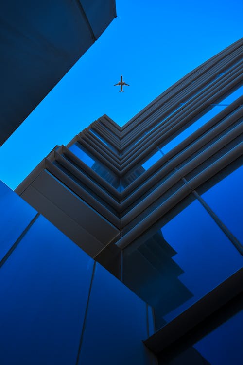 Airplane Flying Over the High Rise Building