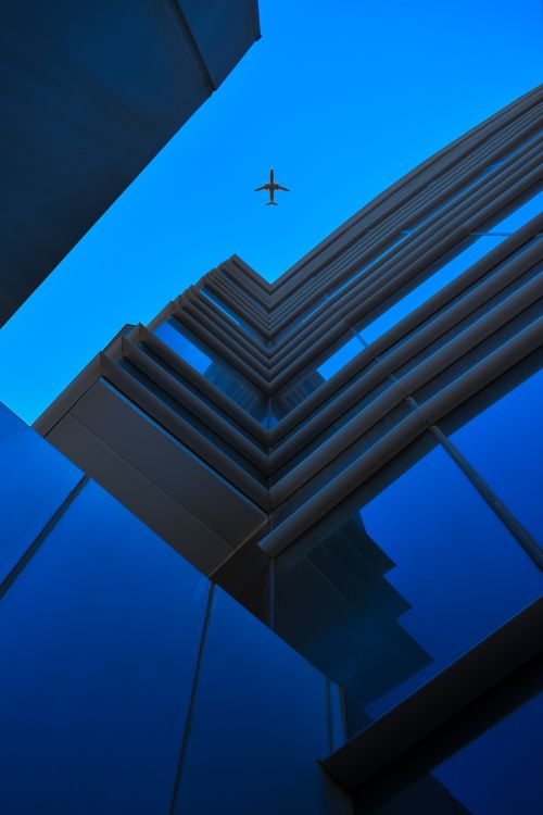 Airplane Flying Over the High Rise Building · Free Stock Photo