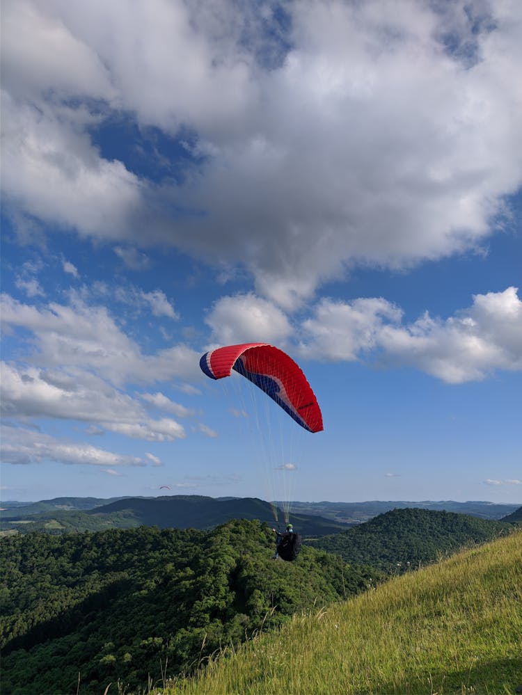 A Person Paragliding On The Mountain