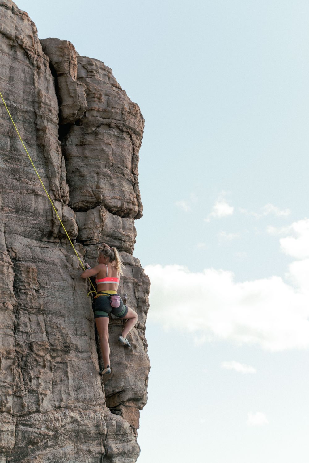 Female climber showing determination on rugged outdoor rock face