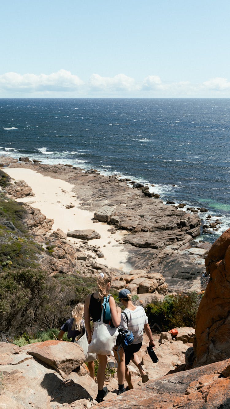 People Walking A Rocky Path To The Beach 