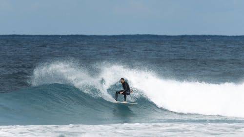Man in Sports Wear Surfing on Sea