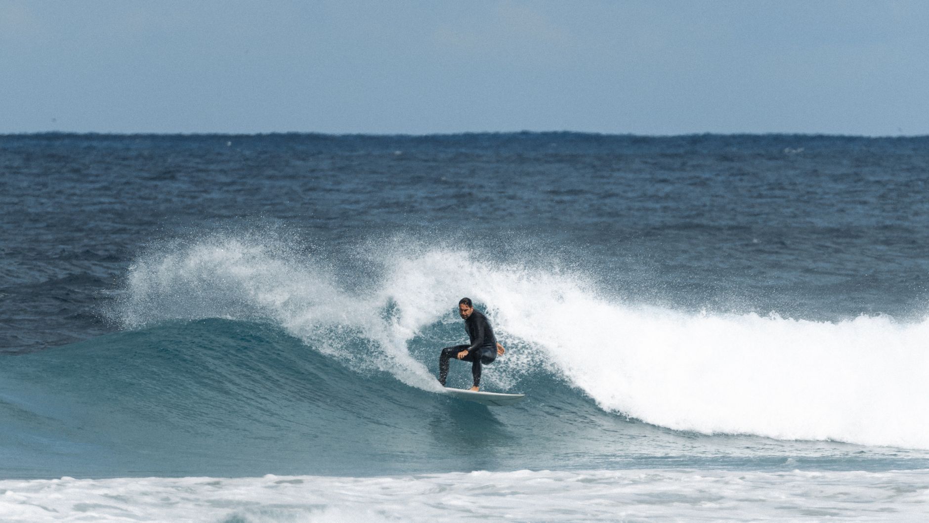 A surfer rides a large Pacific ocean wave with skill and precision — the world-class surf conditions that have put Playa Venao on the map for international buyers.