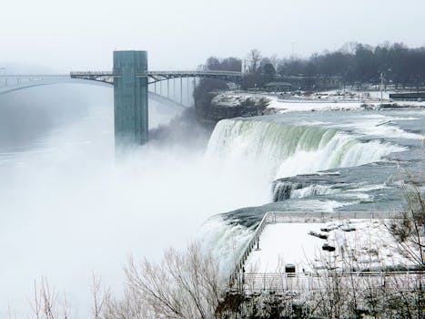 Scenic winter view of Niagara Falls with snow and mist on the American side.