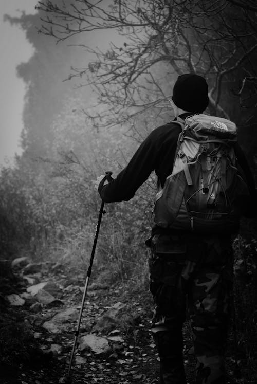 Man with a Backpack Walking on a Rocky Pathway