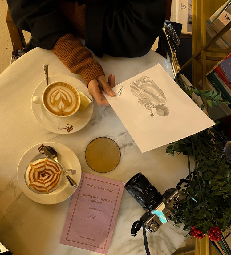 Woman Sitting At A Table With Coffee In A Cafe And Holding A Card 