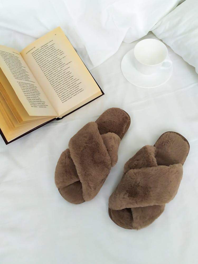 Slippers And Book On Bed