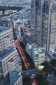 Stunning aerial view of Shinjuku City, Tokyo, showcasing skyscrapers and bustling streets at dusk.