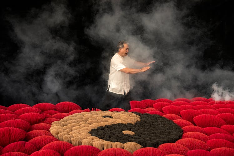 Man Practicing Tai Chi Next To Incenses Forming Ying Yang Symbol