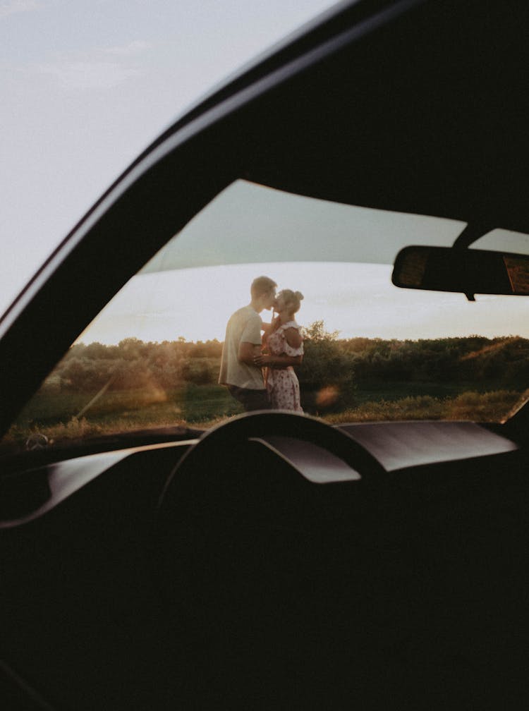 Man And Woman Kissing In Front Of A Car 