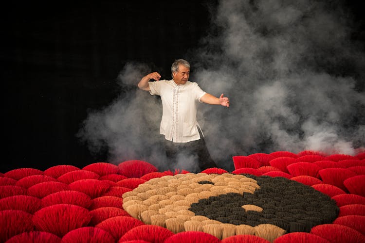 Man Posing In Smoke Among Colorful Flowers