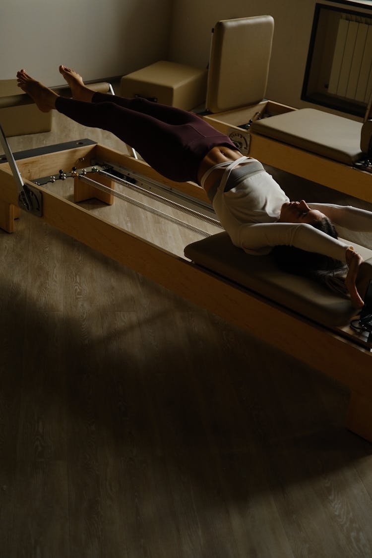 Woman Stretching On Device In Room