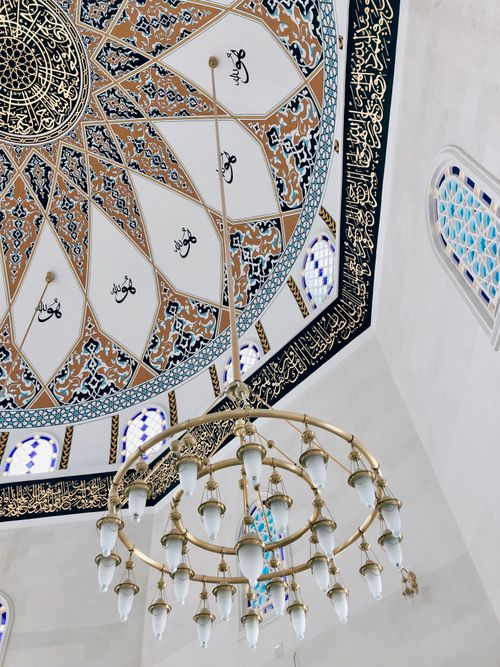 Free Detailed view of an ornate mosque ceiling and chandelier with Arabic calligraphy. Stock Photo