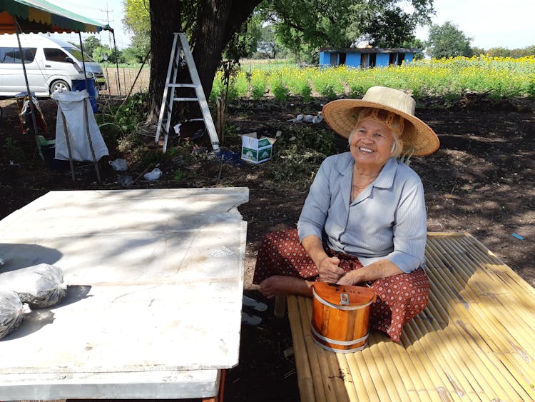 Photo Of An Elderly Woman Sitting Near A Bucket