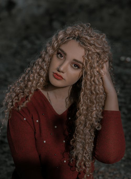Portrait of a Curly-Haired Woman in Red Long Sleeves