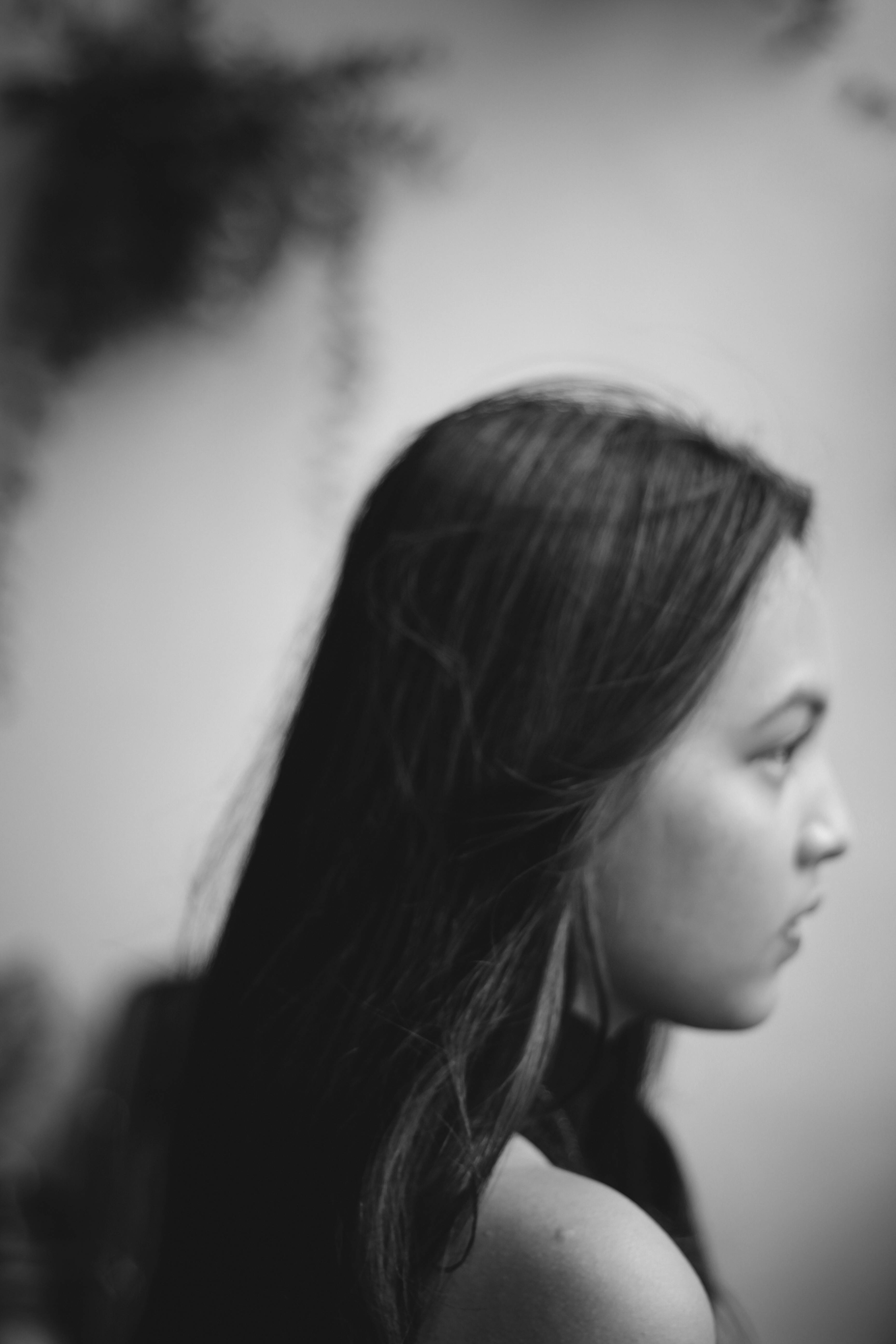 Black and white side profile portrait of a woman in a contemplative pose.