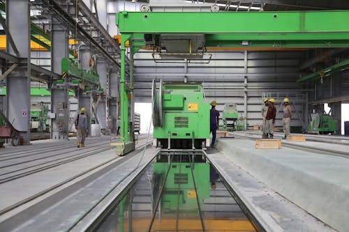 бесплатная Люди стоят возле зеленой металлической промышленной машины Стоковое фото