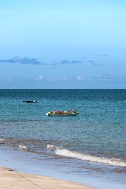 People Riding on Yellow and White Boat on Sea