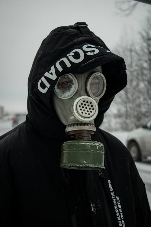 Free A Person in Black and White Hoodie Wearing a Gas Mask Stock Photo