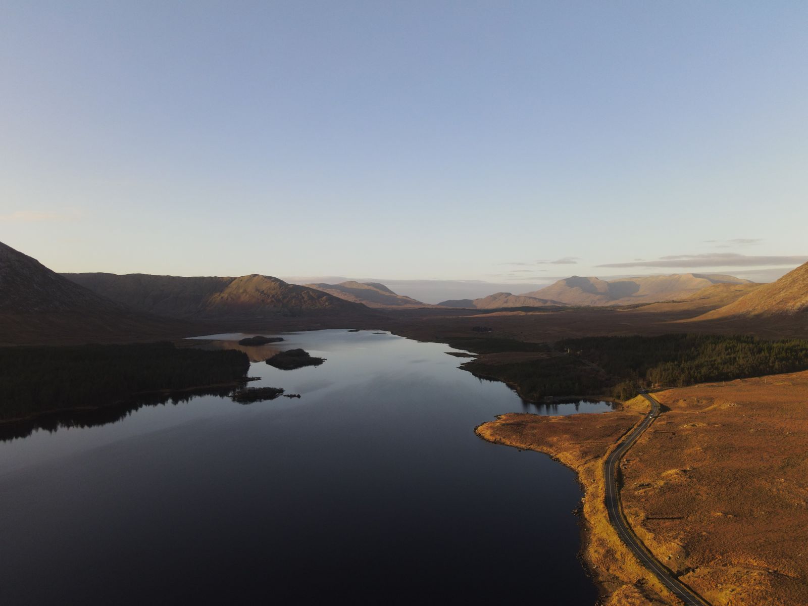 Aerial view of Lough Inagh reflecting mountain shadows at sunset in Connemara, Ireland