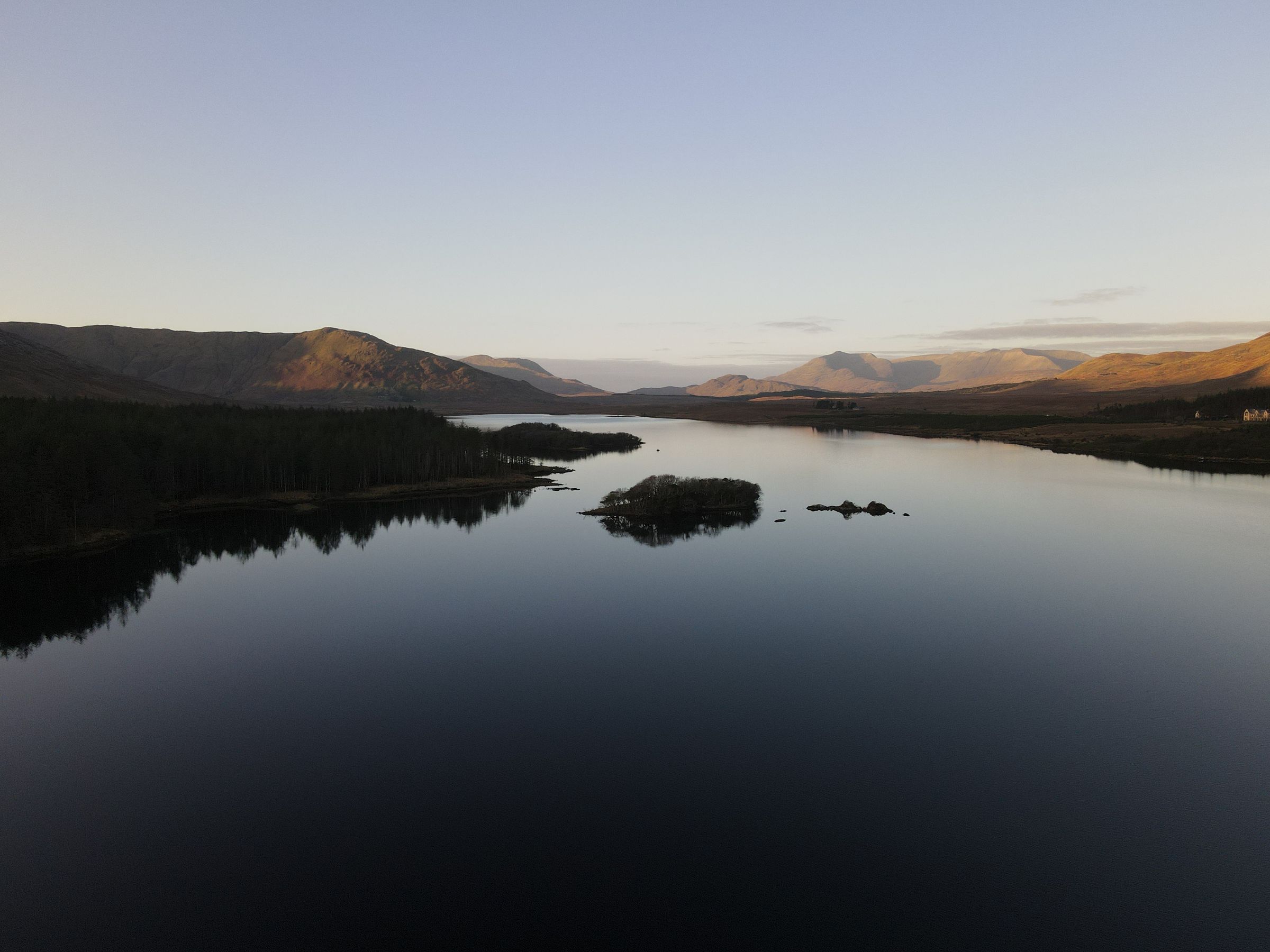 Aerial view of a lake among green hills in Connemara