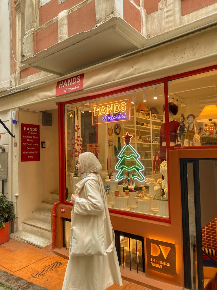 A Woman In Hijab Standing Outside The Store