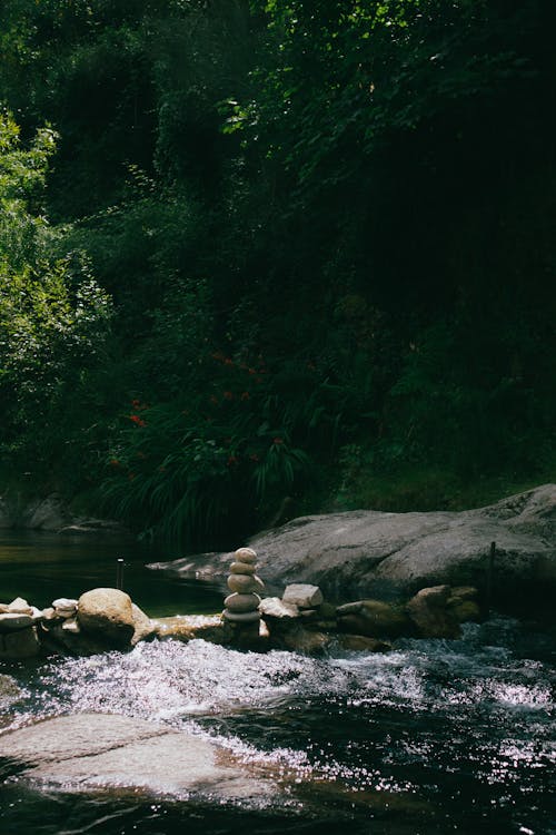 Flowing River Beside Stone Stacking