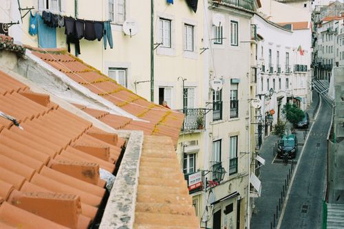 Free Charming Lisbon street with traditional rooftops and laundry hanging out to dry, capturing local architecture. Stock Photo