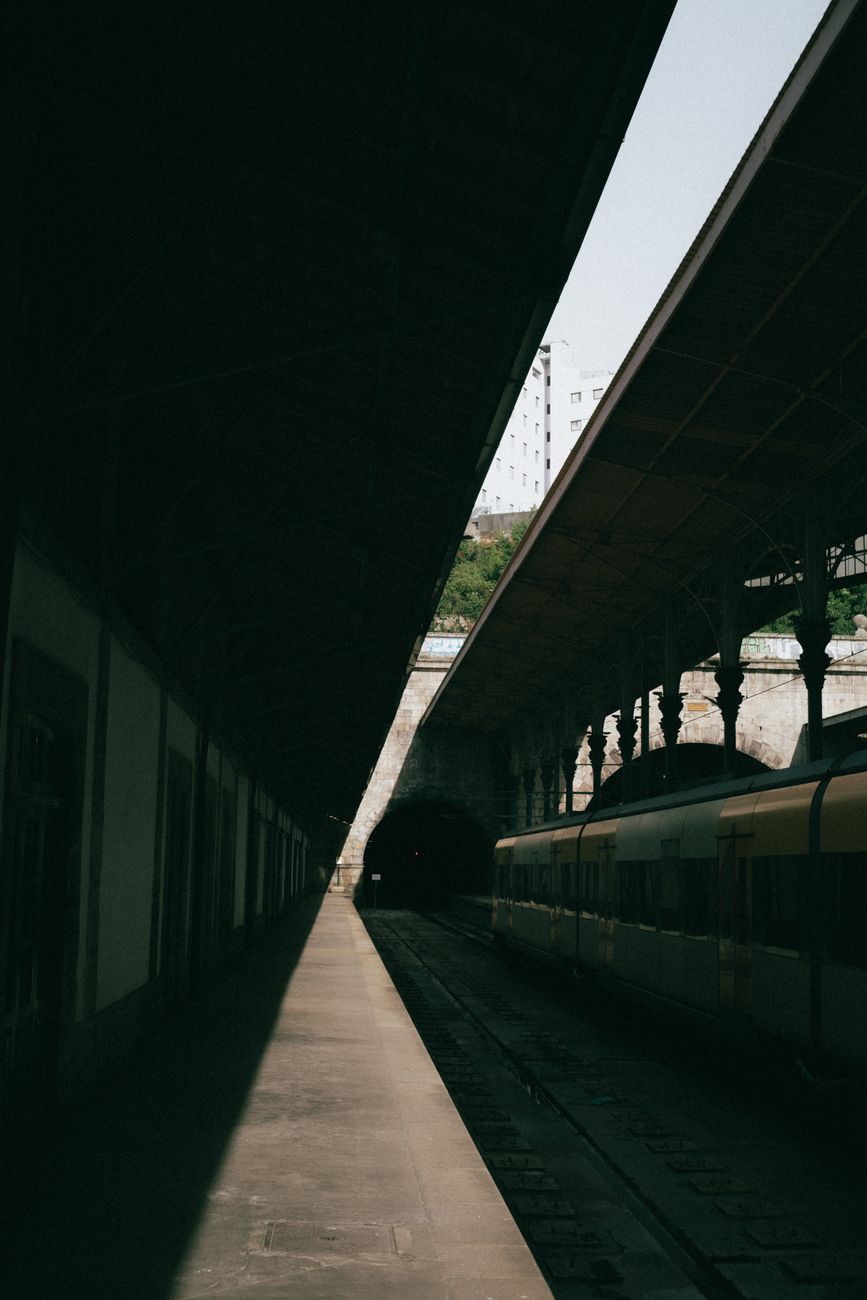 A tranquil scene at a train station platform in Porto, Portugal, featuring a waiting train.