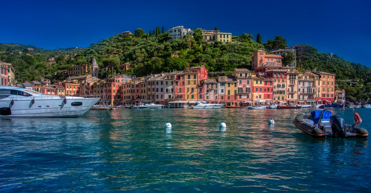 Beautiful view of Portofino's colorful waterfront with boats on a sunny day.
