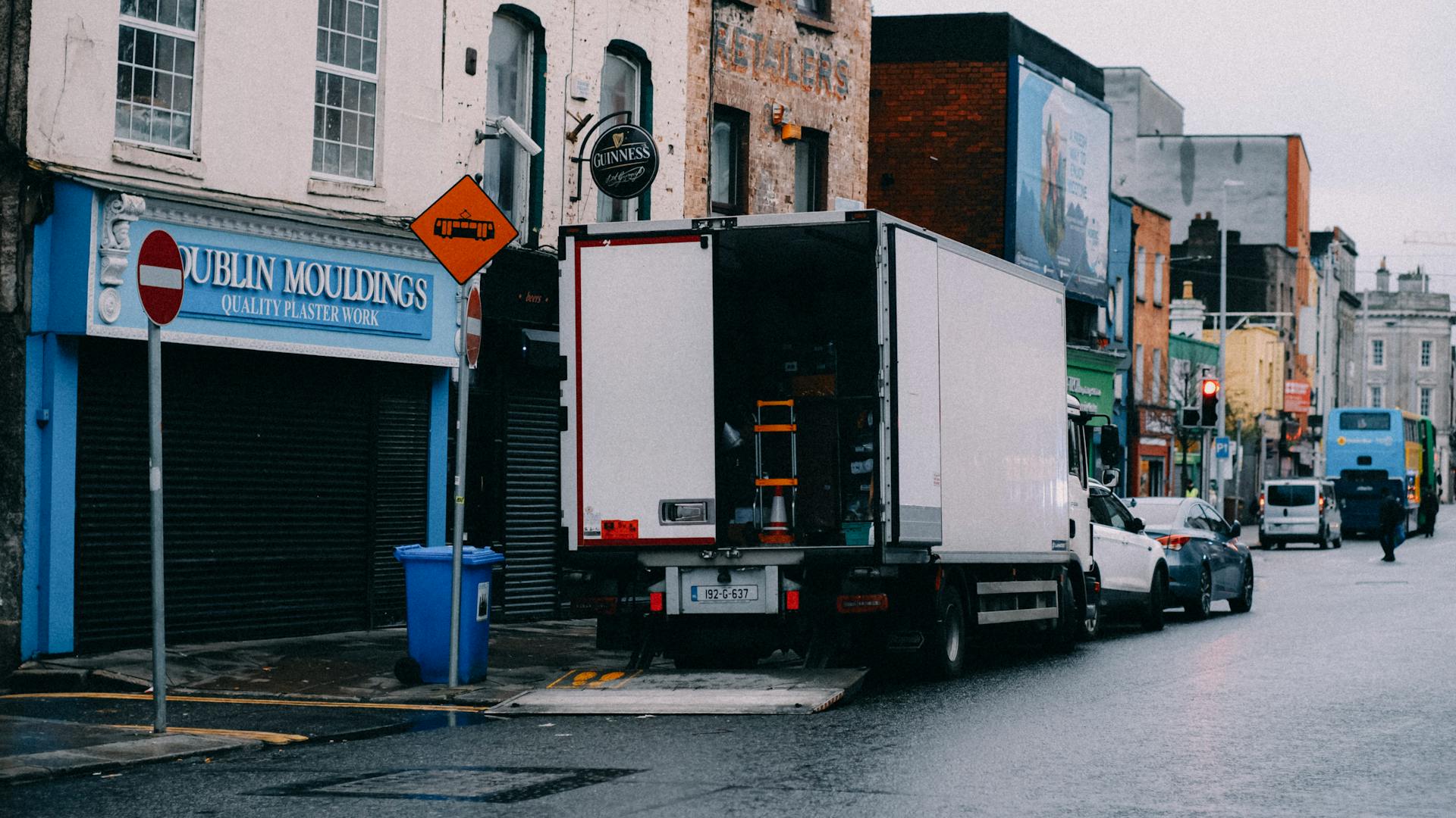 Urban street scene in Dublin featuring a delivery truck and local shops.