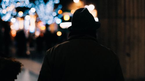 Free Silhouette of a person in an urban night setting with bokeh lights. Stock Photo
