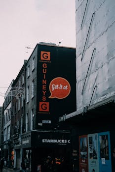 Street view of buildings with visible Starbucks and advertisement signage in a city setting.