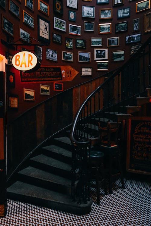 Photo of a Bar Signage Near a Black Staircase