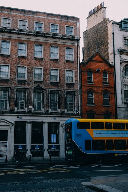 Free  Double-Decker Bus In Front of Concrete Buildings Stock Photo