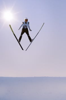 Ski jumper in mid-air against a sunny winter sky at Eau Claire, WI.