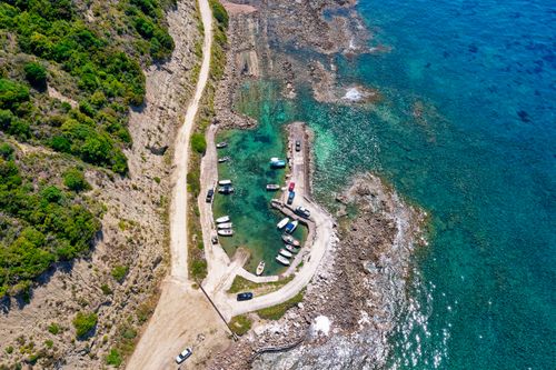 Free A stunning aerial view of Kerkira's rocky coastline, featuring anchored boats and clear turquoise waters. Stock Photo