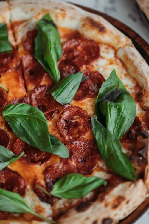 Free Pizza Pepperoni with Salami and Basil on Top Stock Photo