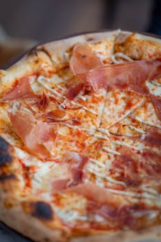 Close-up of a traditional Italian pizza topped with Parma ham.
