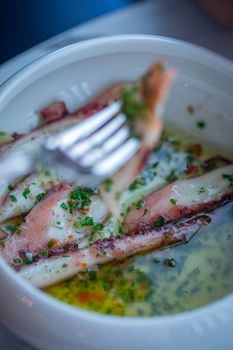 Close-up of gourmet dish featuring tender seafood in a flavorful herb sauce.