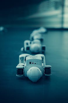 Vertical shot of white robots aligned on a dark surface, emphasizing technology.