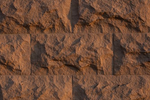 Close-up of a rough textured stone wall with natural patterns and earthy tones.
