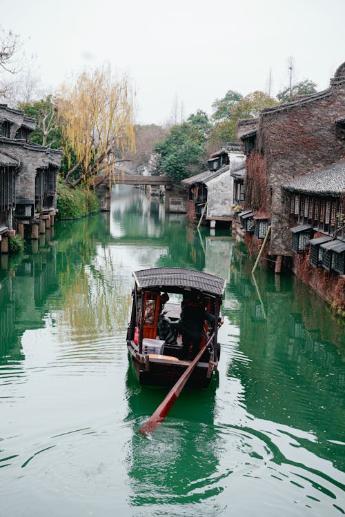 Brown Wooden Boat Sailing on the Canal