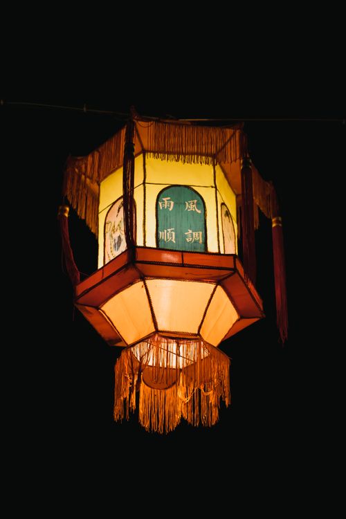 Free Captivating shot of a traditional Chinese lantern glowing against a dark night sky. Stock Photo