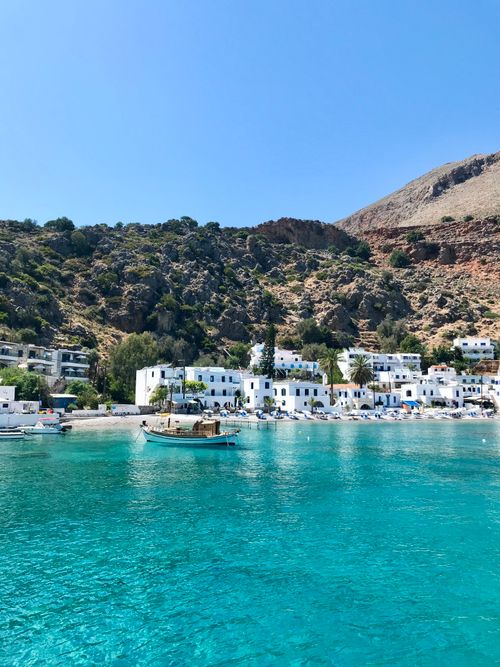 Free Charming coastal village with turquoise waters and serene mountain backdrop. Stock Photo