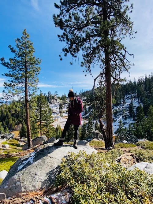 Woman Wearing a Jacket Standing on a Big Rock