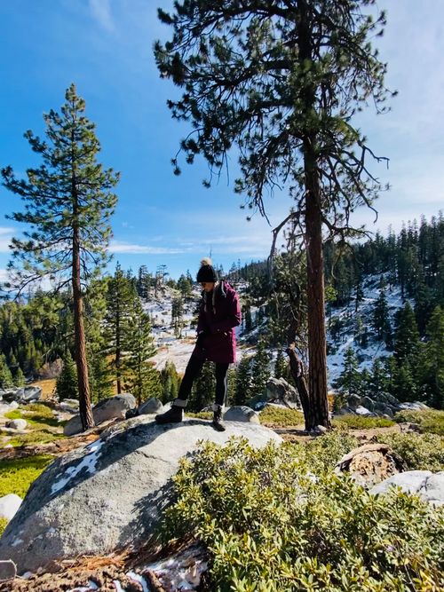 Free Woman hiker in winter gear explores snow-covered mountain terrain. Stock Photo