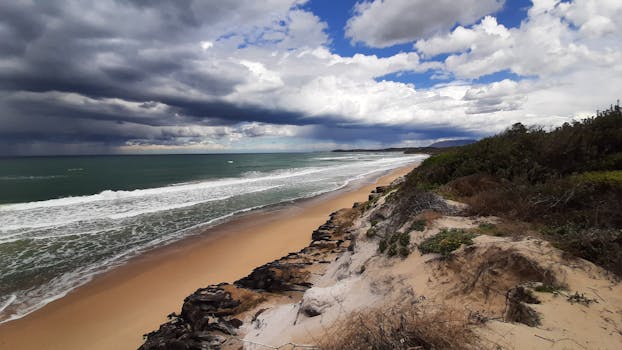 A stunning view of Port Macquarie's beach with dramatic clouds and waves.