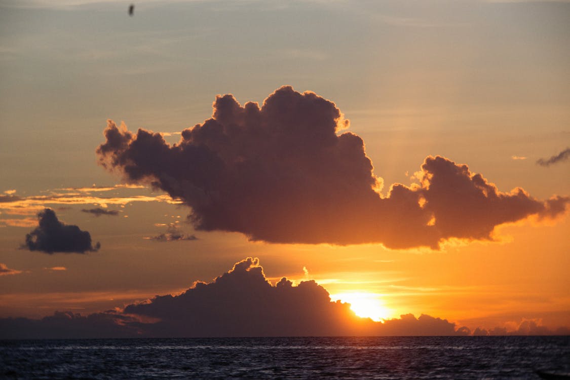 Body of Water Under Cloudy Sky during Sunset